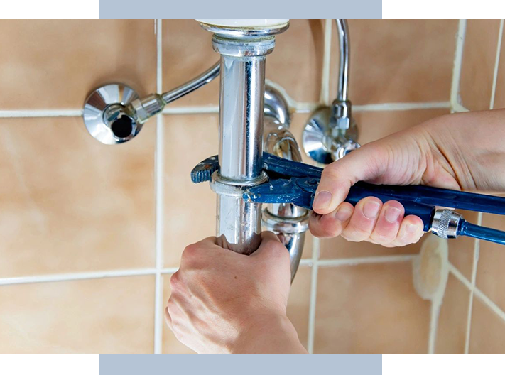 A person is fixing the faucet of a bathroom.