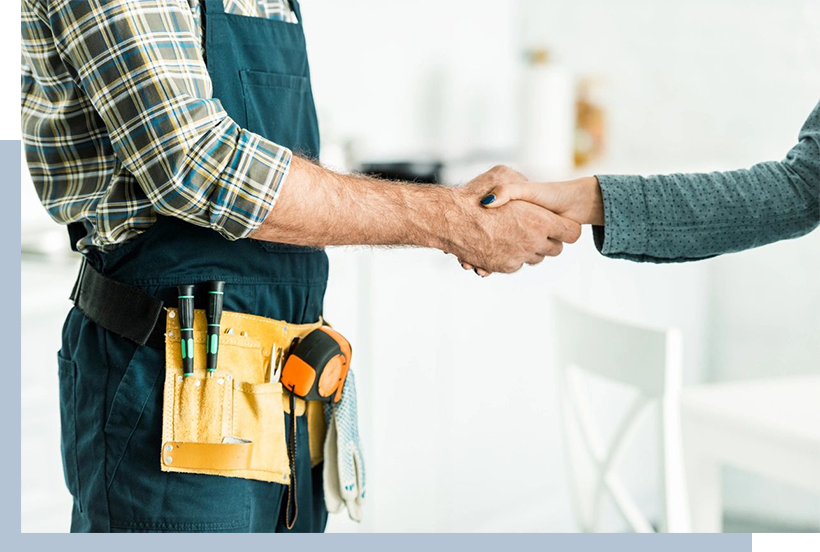 A man in an apron shaking hands with another person.