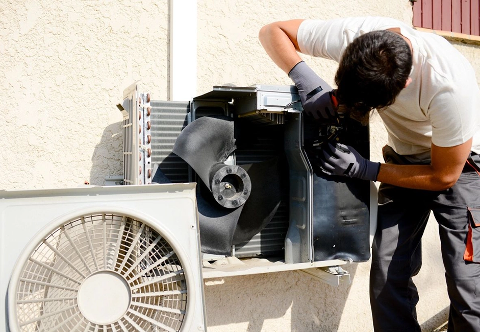 A man working on an air conditioner unit.
